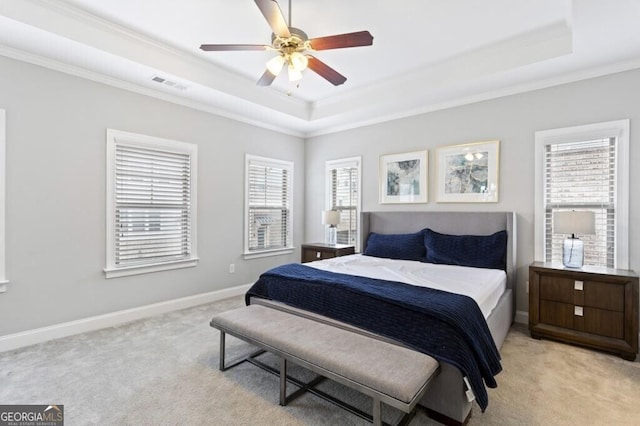 carpeted bedroom featuring crown molding, ceiling fan, and a raised ceiling