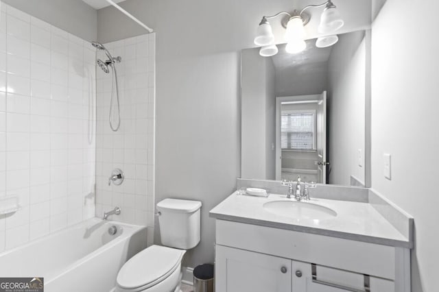 full bathroom featuring tiled shower / bath, vanity, and toilet