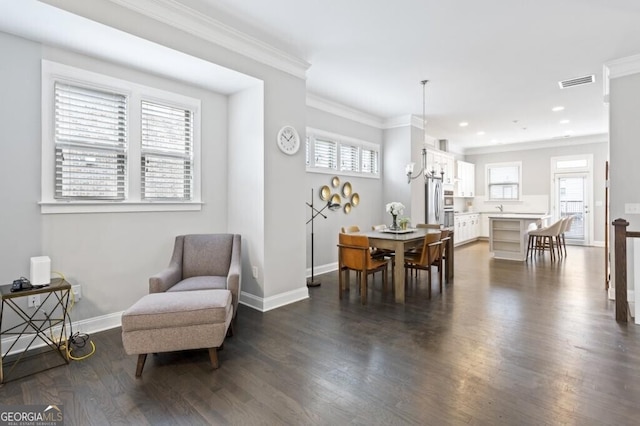 sitting room with crown molding, dark wood-type flooring, and a healthy amount of sunlight