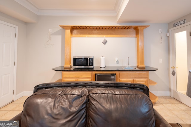 bar featuring light tile patterned floors, crown molding, light brown cabinetry, and sink