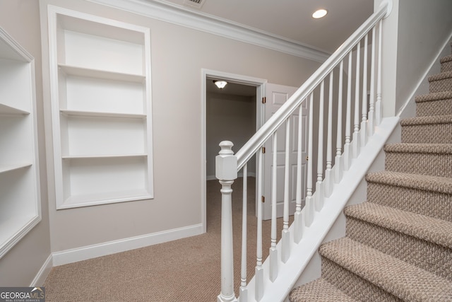 stairs with carpet floors and crown molding