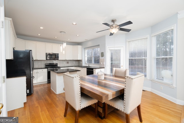 dining room with ceiling fan, light hardwood / wood-style flooring, and sink