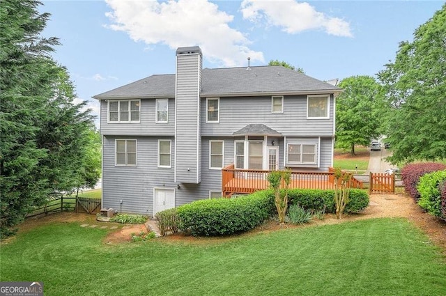 back of property with a deck and a lawn