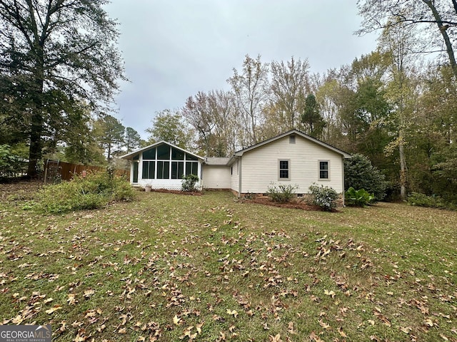 back of property with a yard and a sunroom