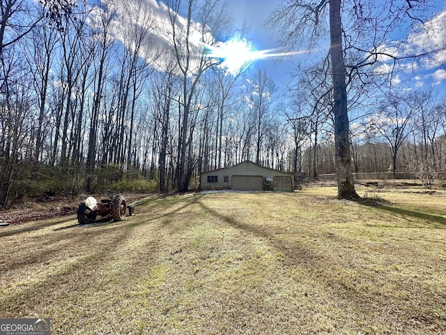 view of yard with a garage and an outbuilding