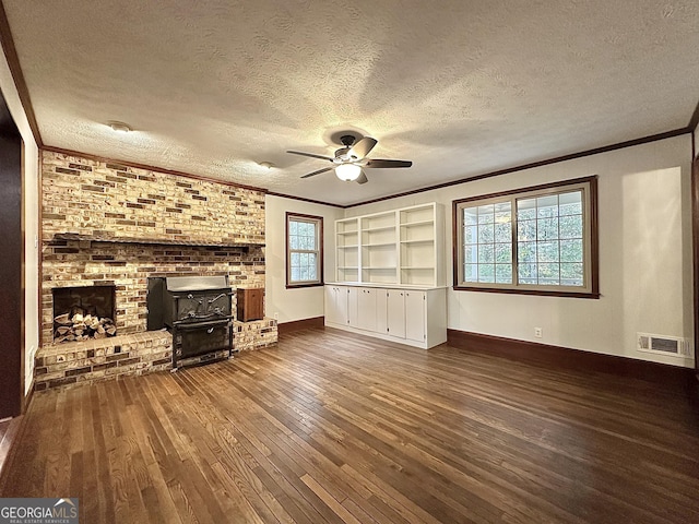 unfurnished living room featuring crown molding, ceiling fan, hardwood / wood-style floors, a textured ceiling, and built in shelves