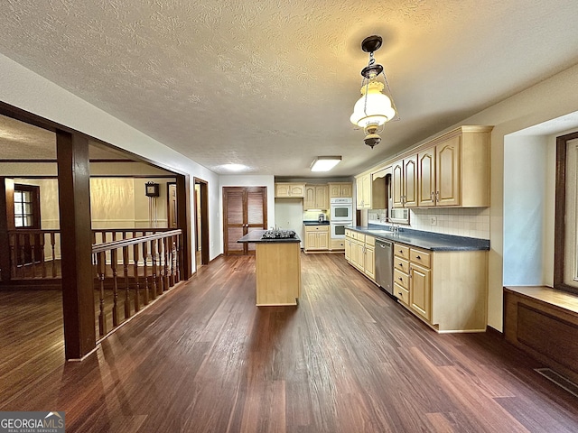 kitchen featuring dark wood-type flooring, appliances with stainless steel finishes, a kitchen island, decorative light fixtures, and light brown cabinets