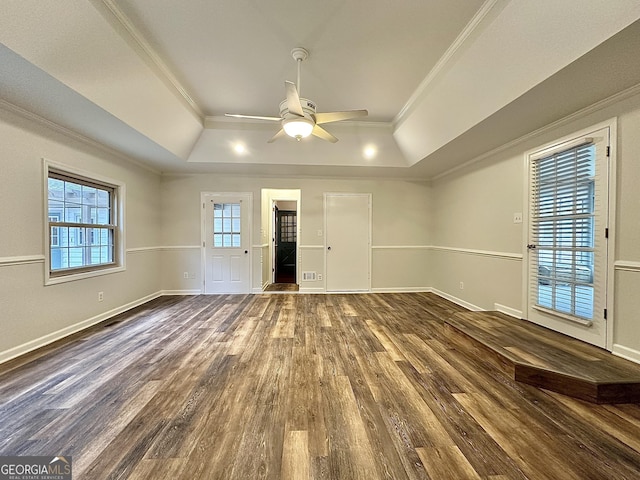 spare room with crown molding, a tray ceiling, dark hardwood / wood-style floors, and ceiling fan