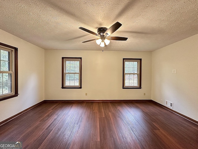 unfurnished room featuring dark wood-type flooring, ceiling fan, and plenty of natural light