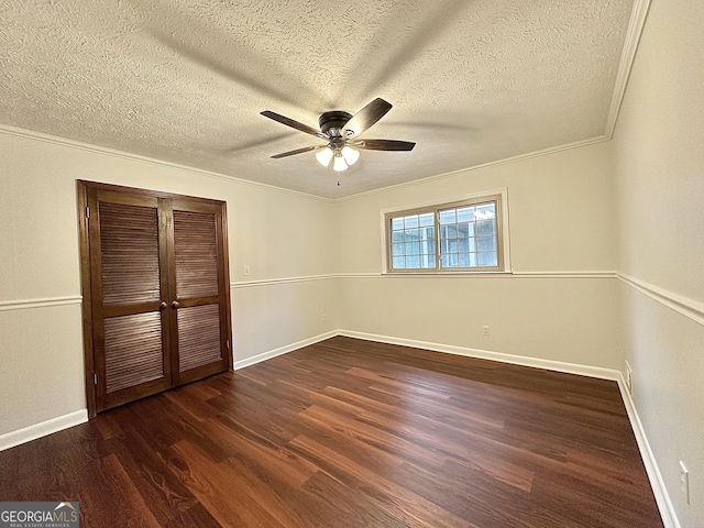 unfurnished bedroom with ceiling fan, dark hardwood / wood-style floors, ornamental molding, a textured ceiling, and a closet