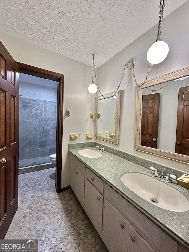 bathroom featuring walk in shower, vanity, toilet, and a textured ceiling