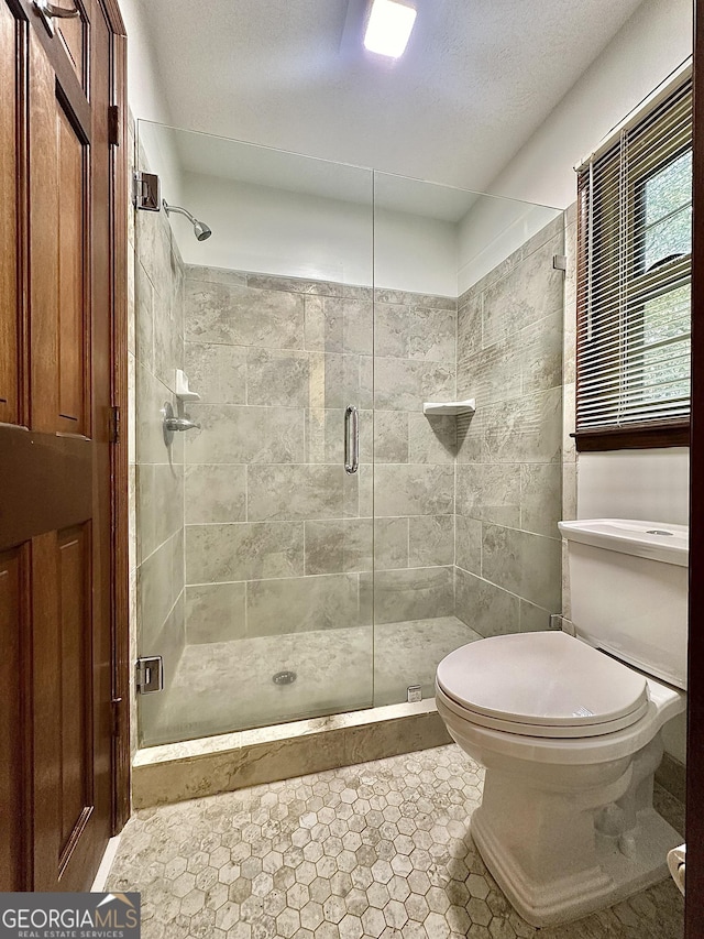 bathroom with an enclosed shower and toilet