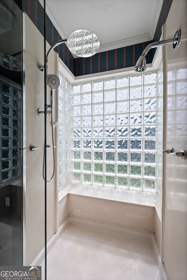 bathroom featuring a wealth of natural light, ornamental molding, and tiled shower