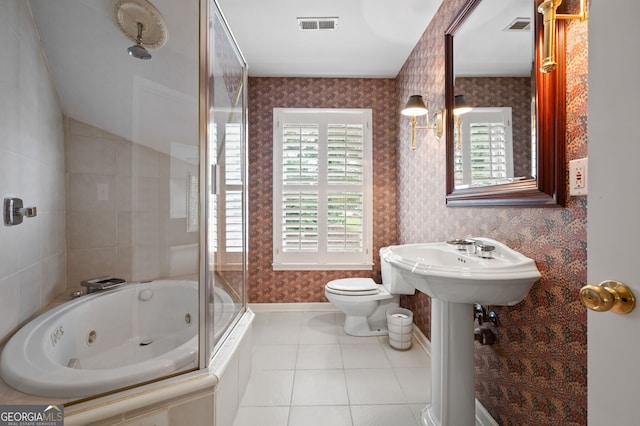 bathroom featuring tiled shower / bath combo, tile patterned floors, and toilet