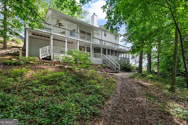 rear view of house featuring a balcony and ceiling fan