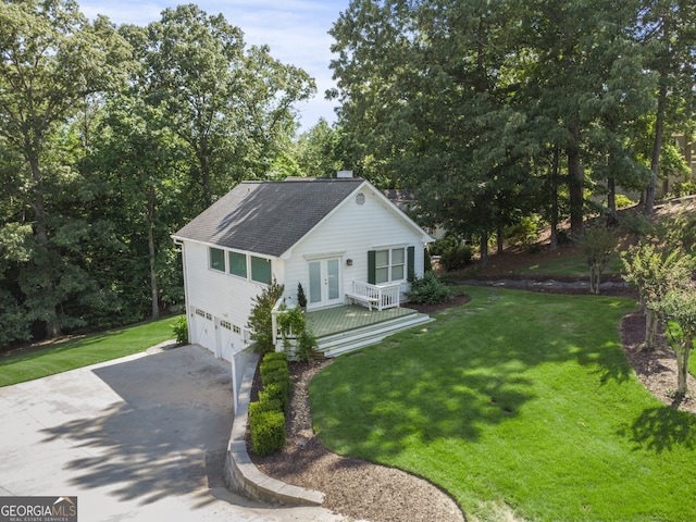 view of front of home featuring a garage, a front yard, french doors, and a deck