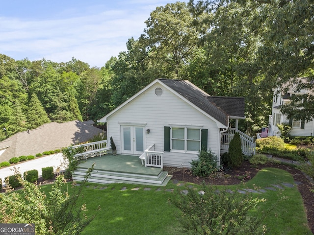 back of house featuring a wooden deck, a yard, and french doors