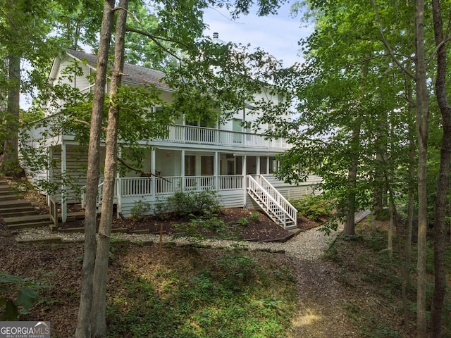 back of house featuring a balcony and covered porch