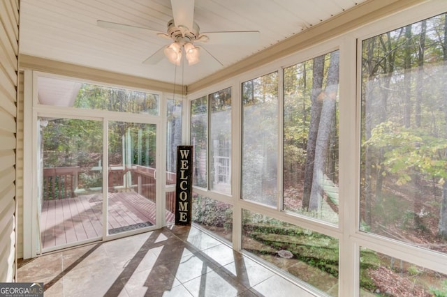 unfurnished sunroom featuring ceiling fan