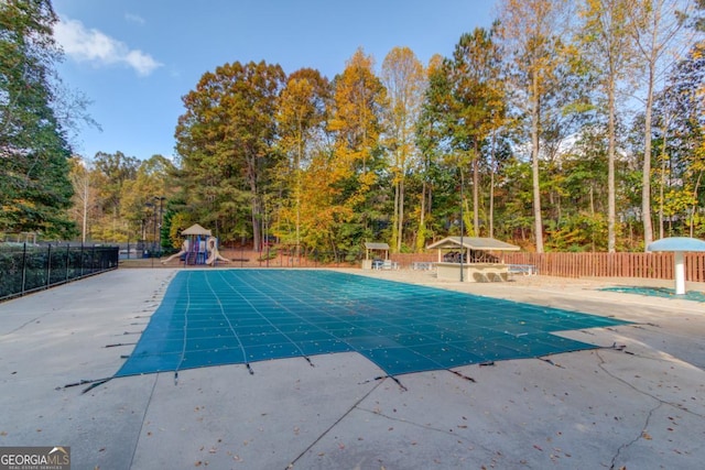 view of swimming pool with a playground