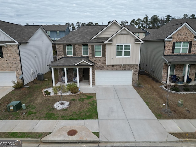 view of front of house featuring cooling unit, a garage, and covered porch