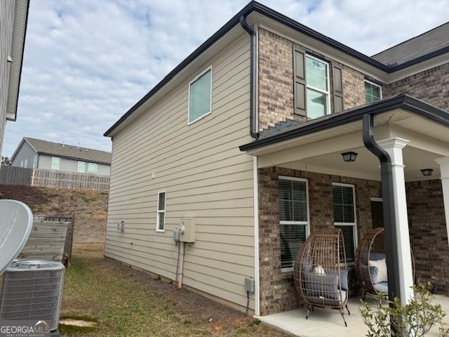 view of home's exterior featuring cooling unit and a patio