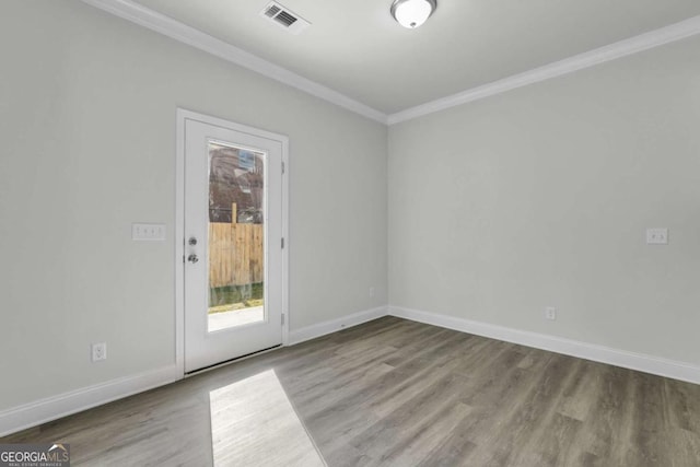 empty room featuring crown molding and hardwood / wood-style floors