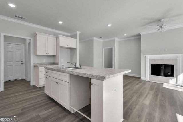 kitchen featuring a kitchen island with sink, sink, dark hardwood / wood-style flooring, and white cabinets