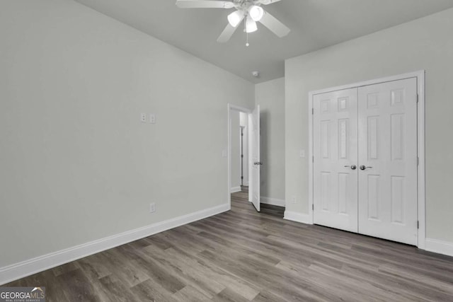 unfurnished bedroom with hardwood / wood-style floors, ceiling fan, and a closet