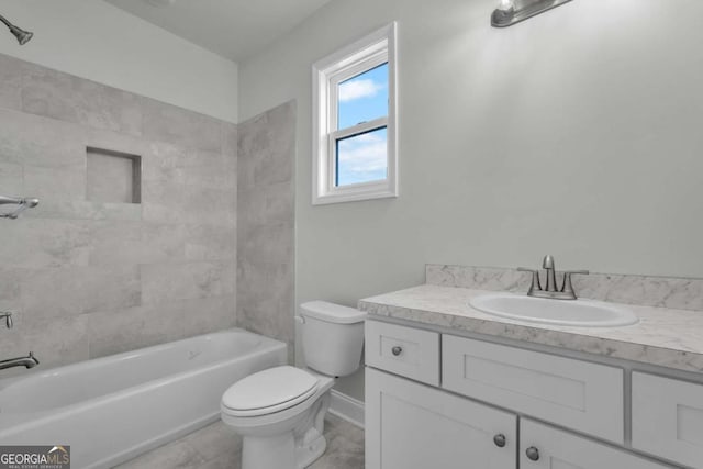 full bathroom featuring tiled shower / bath, vanity, and toilet