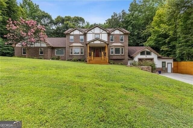 tudor-style house with a front lawn