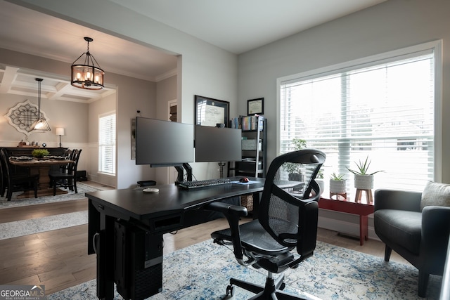 office space featuring hardwood / wood-style floors, beamed ceiling, a chandelier, ornamental molding, and coffered ceiling