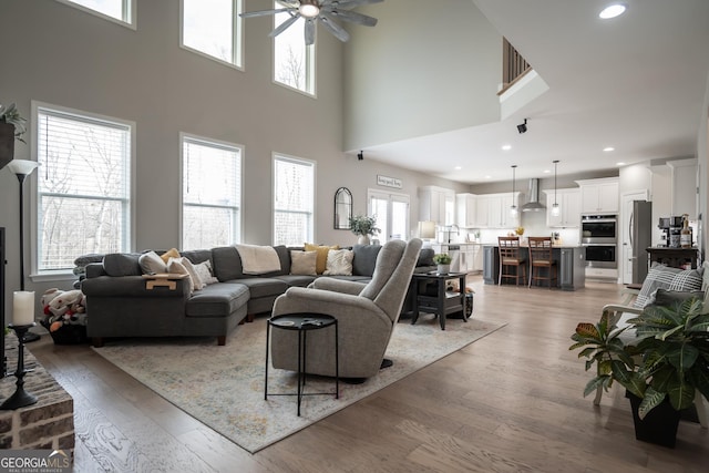 living room with ceiling fan, sink, and light hardwood / wood-style floors