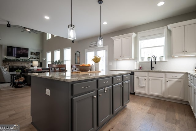 kitchen featuring sink, white cabinetry, gray cabinets, a kitchen island, and light hardwood / wood-style floors