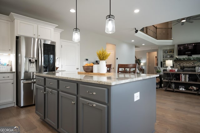 kitchen with dark hardwood / wood-style floors, pendant lighting, white cabinetry, a center island, and stainless steel refrigerator with ice dispenser