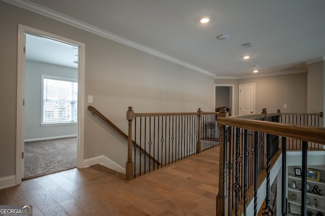 hall with ornamental molding and hardwood / wood-style floors