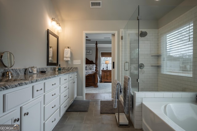 bathroom with vanity and shower with separate bathtub