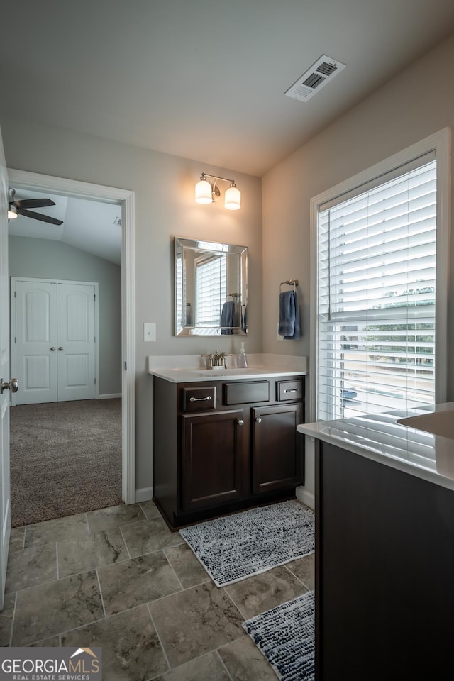 bathroom with ceiling fan, vanity, and lofted ceiling