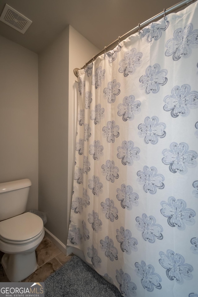 bathroom featuring tile patterned flooring, toilet, and a shower with shower curtain