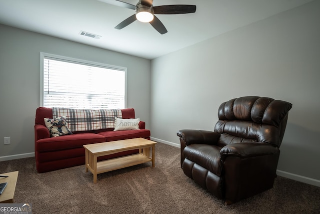 living room featuring dark colored carpet and ceiling fan