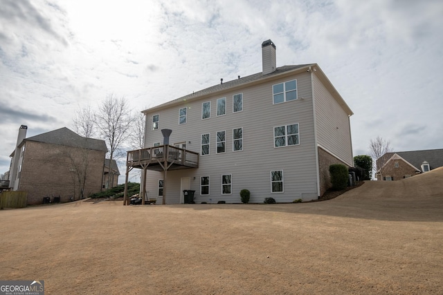 rear view of property featuring a wooden deck and a yard