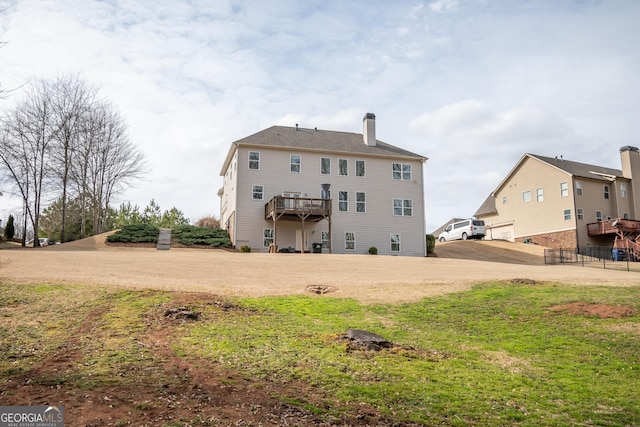 rear view of house with a yard and a deck