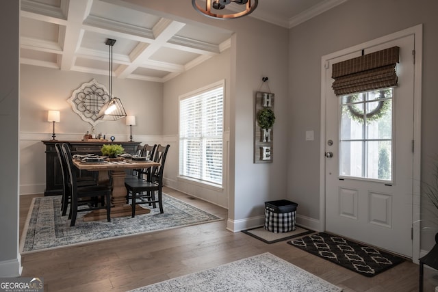 dining area with crown molding, wood-type flooring, coffered ceiling, and beam ceiling