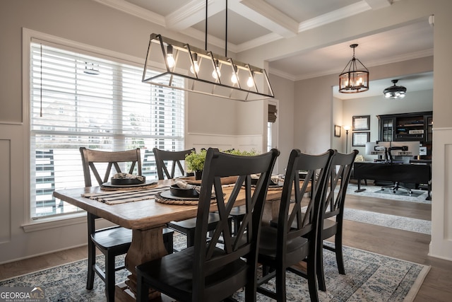 dining area featuring hardwood / wood-style floors, ornamental molding, coffered ceiling, a notable chandelier, and beam ceiling