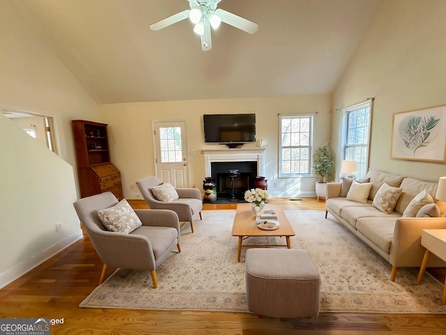 living room with ceiling fan, wood-type flooring, high vaulted ceiling, and a wealth of natural light