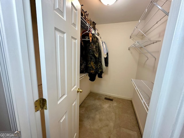 walk in closet featuring light carpet