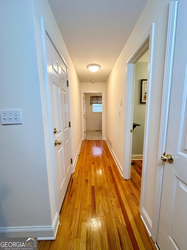 corridor with light hardwood / wood-style floors