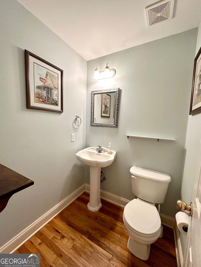 bathroom featuring wood-type flooring and toilet