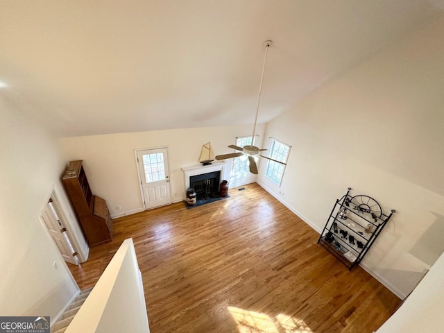 living room with wood-type flooring, high vaulted ceiling, a healthy amount of sunlight, and ceiling fan