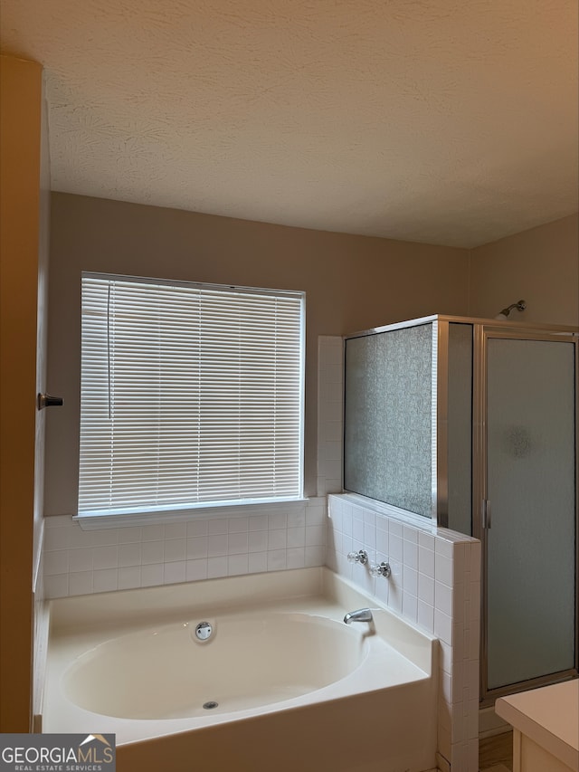 bathroom featuring vanity, plus walk in shower, and a textured ceiling